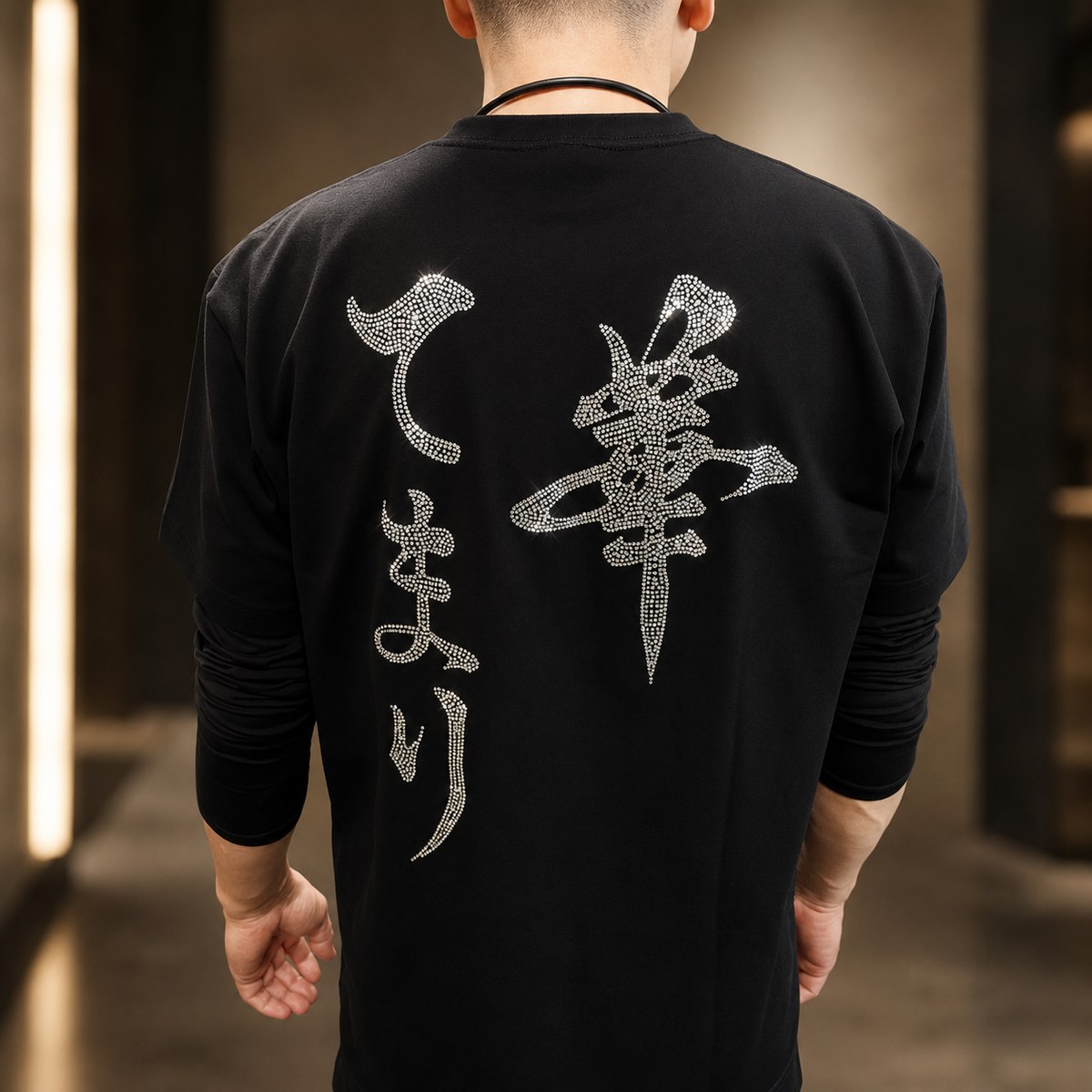 龍のラインストーンデザインを背面に施した黒いTシャツ