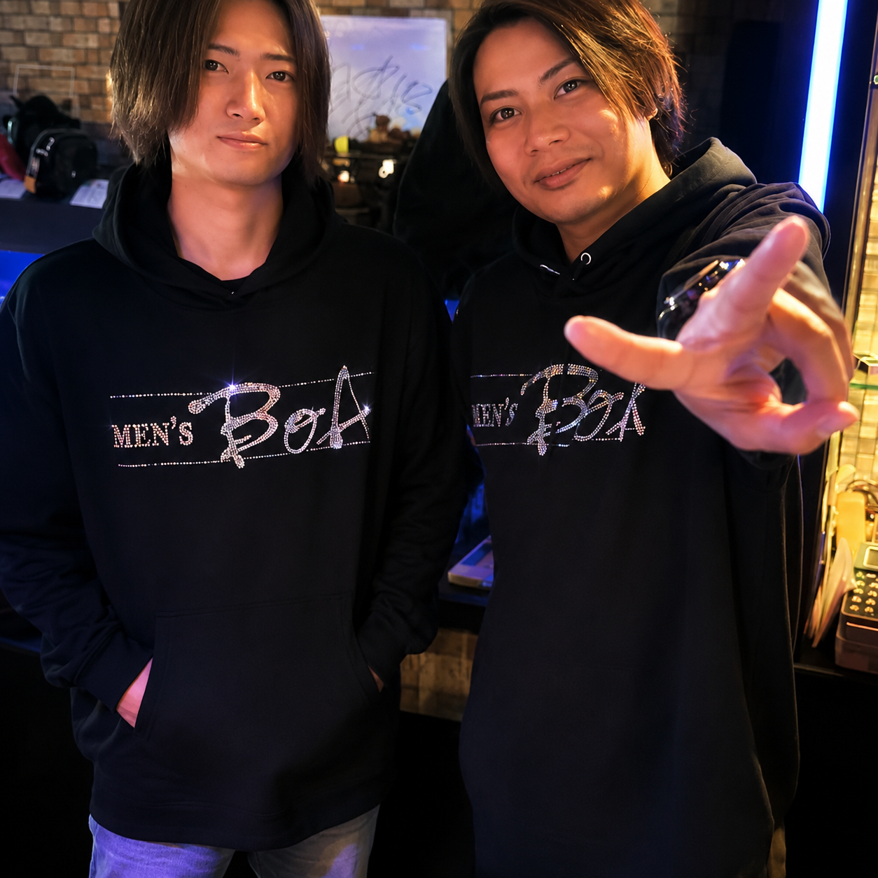 ラインストーンデザインの黒いフーディーを着た二人のモデル